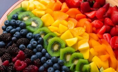 Firefly A vibrant fruit salad arranged in the shape of a rainbow, with each color gradient blending